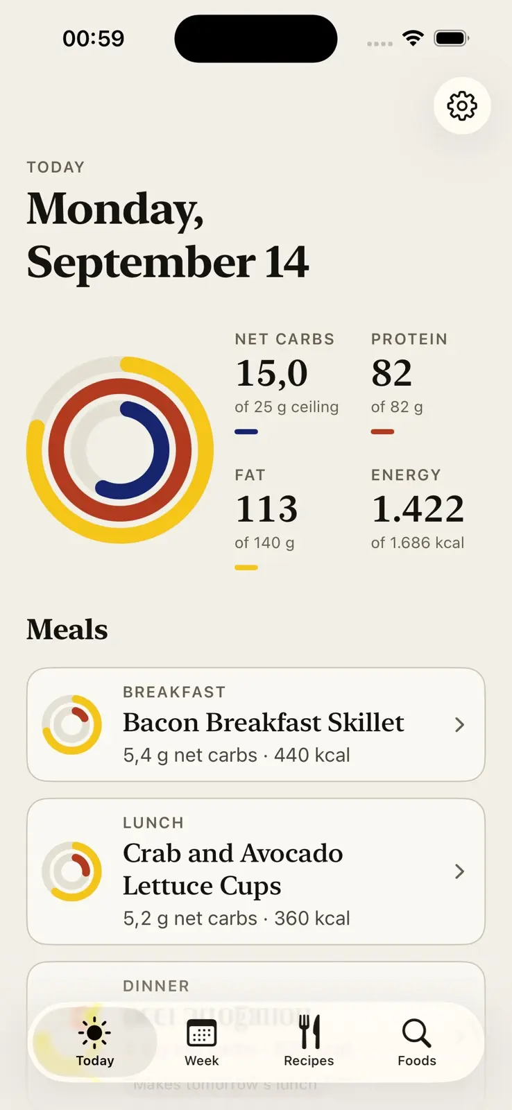 Today's screen, dated Monday, September 14. Three concentric rings, yellow outside, red in the middle and blue inside, each partly filled, beside four figures: 15 grams of net carbs against a 25 gram ceiling, 82 of 82 grams of protein, 113 of 140 grams of fat, and 1,422 of 1,686 kilocalories. Below them the day's meals as cards, a bacon breakfast skillet and crab and avocado lettuce cups, each with a small ring of its own, its net carbs and its energy.